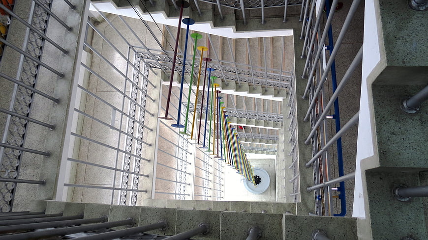 Colorful Hanging Art Installation in Concrete Stairwell