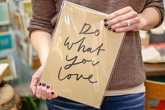 Woman holding inspirational 'Do what you love' print