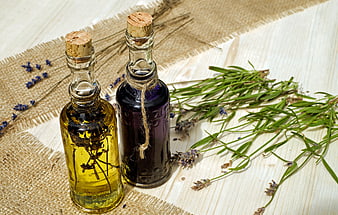 Natural aromatherapy oils with lavender and rosemary on rustic wood