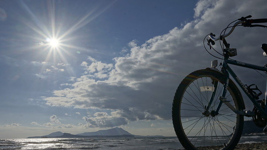 Bicycle on Beach with Sun and Sea Horizon