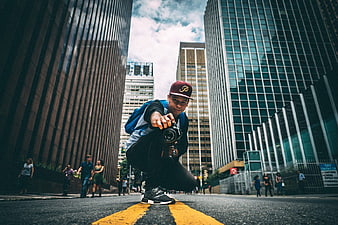 Urban Photographer Squatting with Camera on City Street