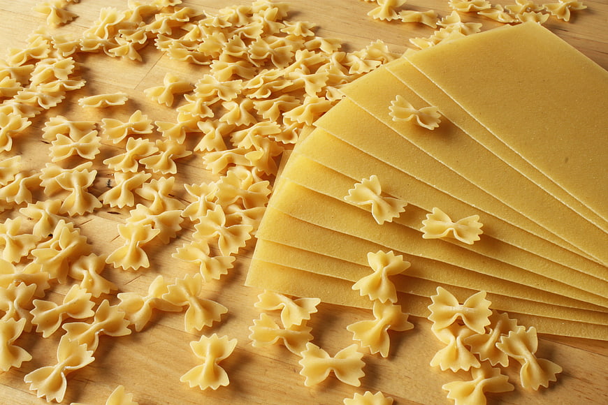 Raw Farfalle Pasta And Lasagna Sheets On Wooden Surface