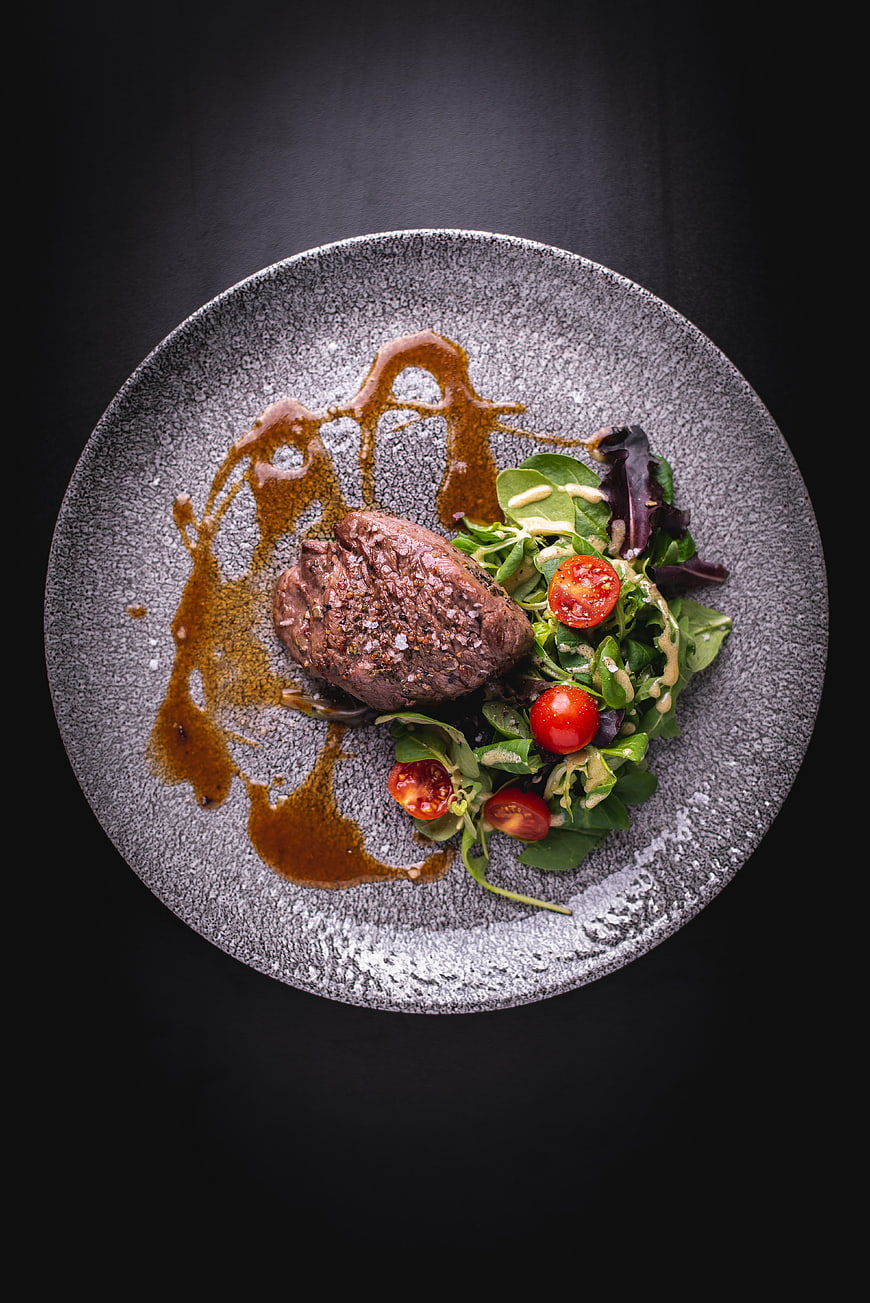 Gourmet Beef Steak With Fresh Salad And Sauce On Textured Plate