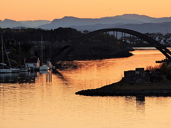 Sunrise over Stavanger harbor with arch bridge and mountains