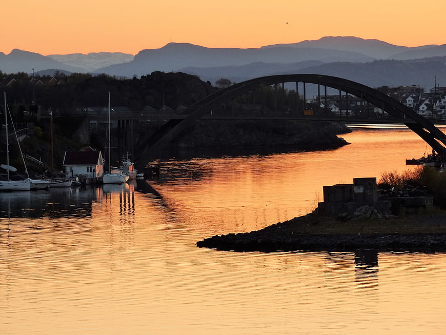 Sunrise over Stavanger harbor with arch bridge and mountains