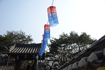 Red and Blue Lanterns Hanging Over Traditional Korean Roof