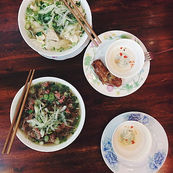 Top view of Vietnamese Pho and spring rolls on wooden table