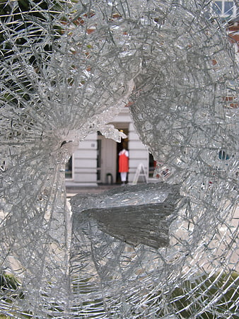 Shattered glass window with hole and blurred background