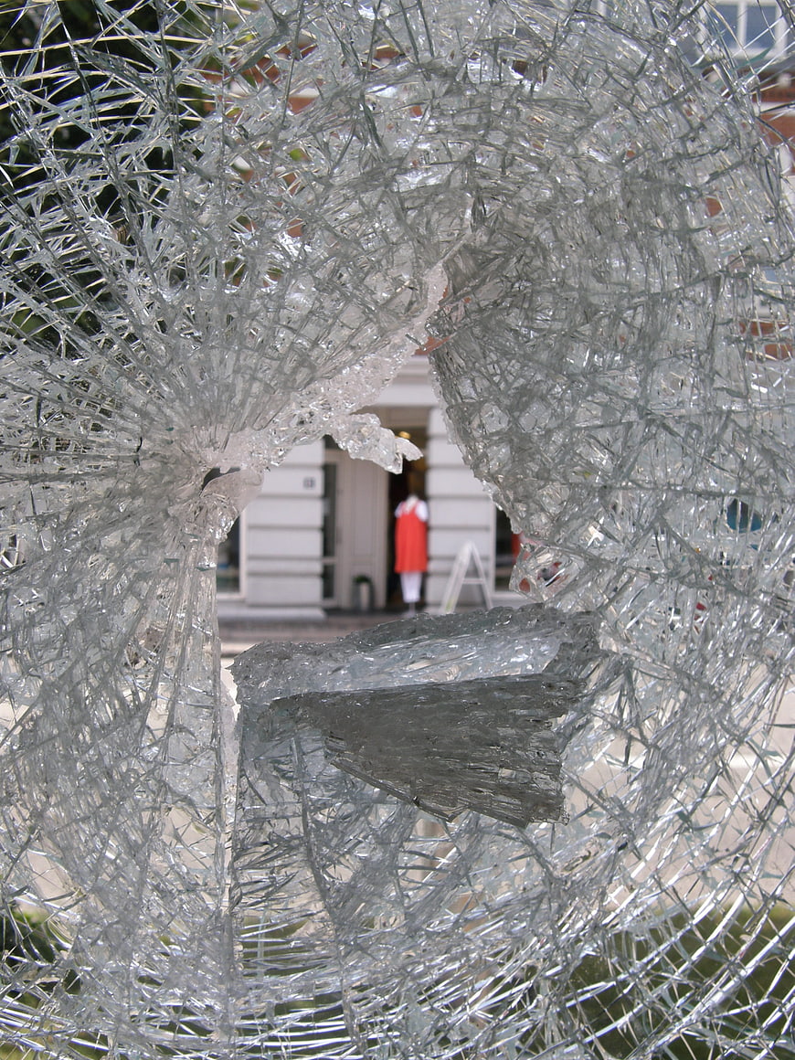 Shattered glass window with hole and blurred background