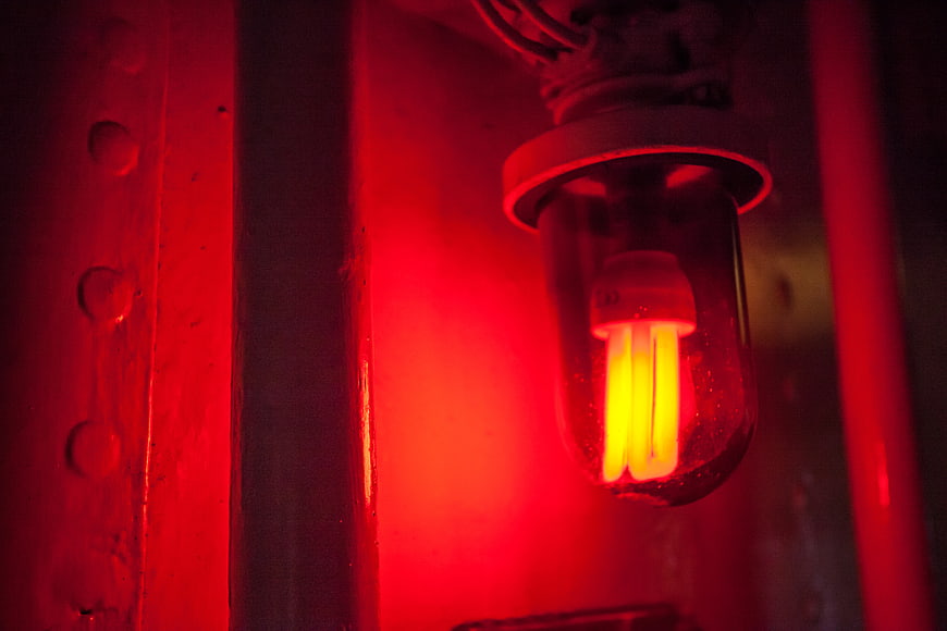 Glowing CFL Bulb Inside Red Glass Industrial Lamp
