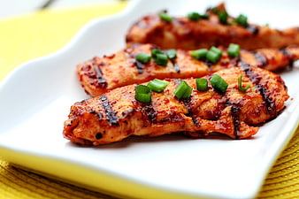 Grilled Spicy Chicken Strips with Green Onions on White Plate