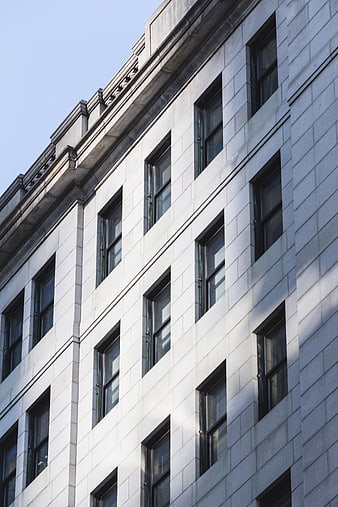Low angle view of white stone building facade with windows