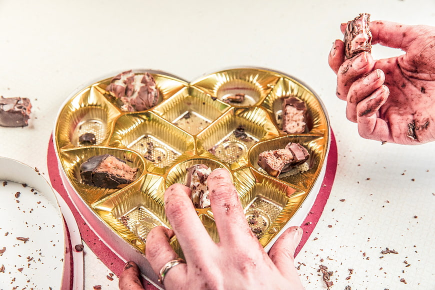 Hands Eating Chocolate from Heart Box