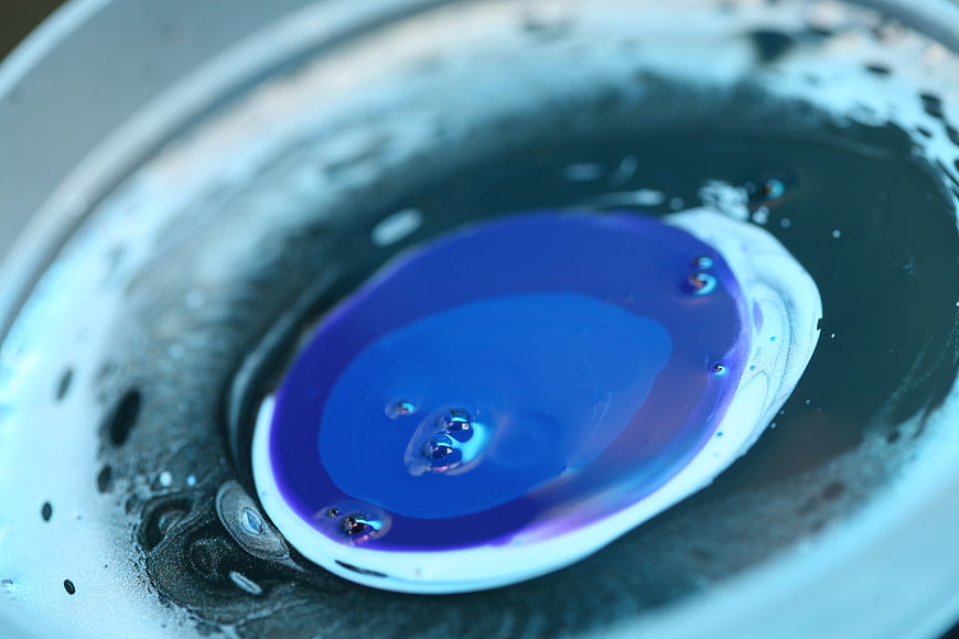 Abstract blue and purple liquid paint swirl in water