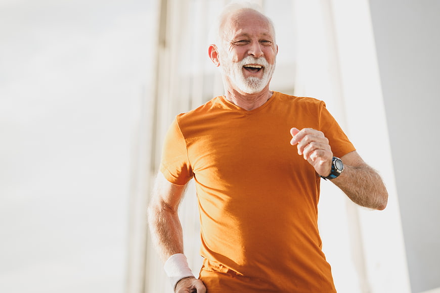 Happy Senior Man Running Outdoors in Orange Shirt