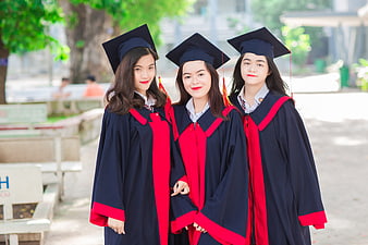 Three Asian Female Graduates in Caps and Gowns