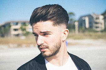Portrait of young man with beard outdoors sunny day