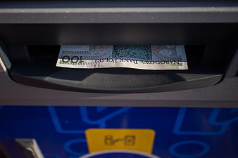 Polish 100 PLN banknote emerging from ATM slot