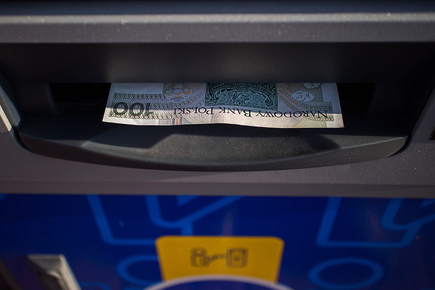 Polish 100 PLN banknote emerging from ATM slot
