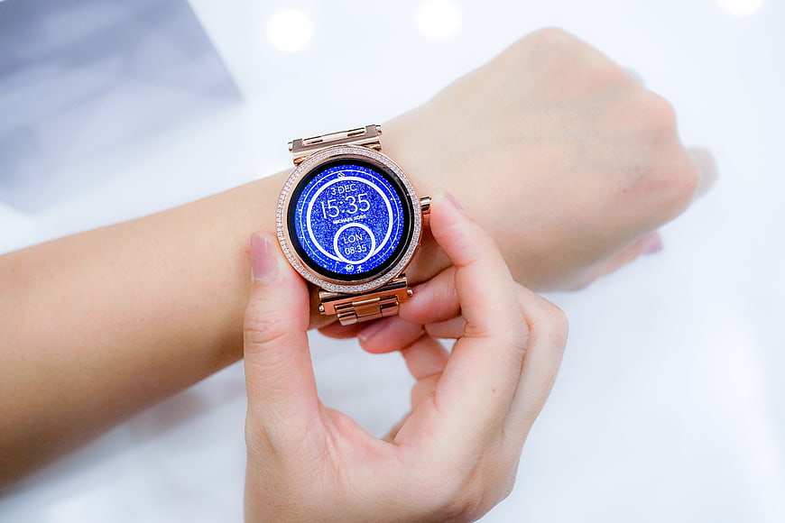 Rose Gold Smartwatch On Wrist With Blue Digital Display