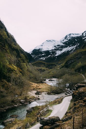 Winding Road Through Snowy Mountain Valley with River