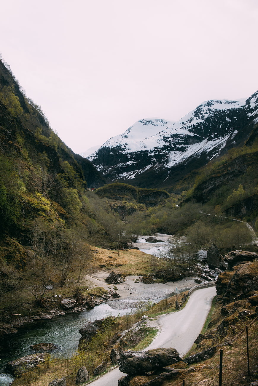 Winding Road Through Snowy Mountain Valley with River