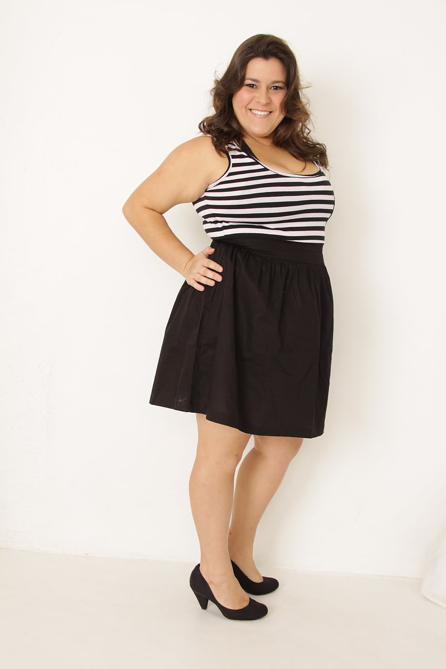 Plus size woman in striped top and black skirt