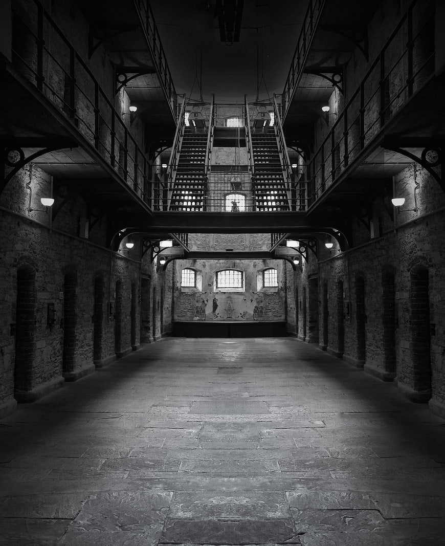 Symmetrical black and white view of historic prison interior