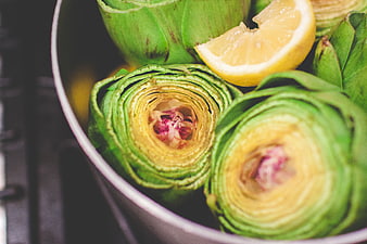 Fresh Artichokes and Lemon Wedge in a Cooking Pot