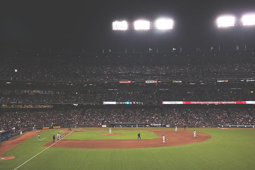 Night baseball game in a crowded stadium with bright lights
