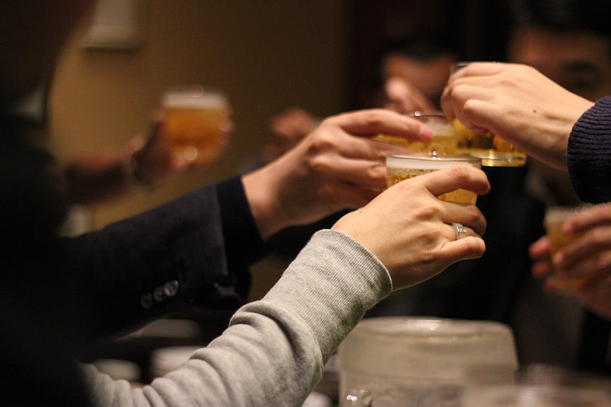Friends toasting with beer glasses at a night gathering