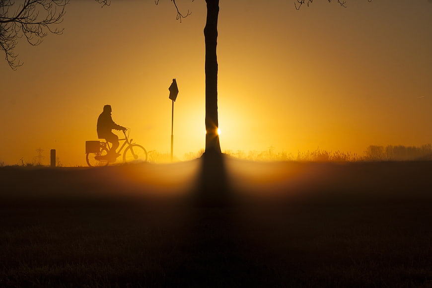 Silhouette of Cyclist Riding at Golden Sunrise