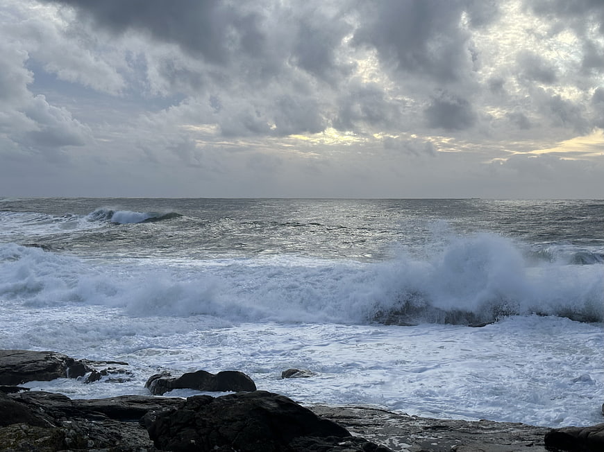 Dramatic Ocean Waves Crashing on Rocky Shore Under Cloudy Sky
