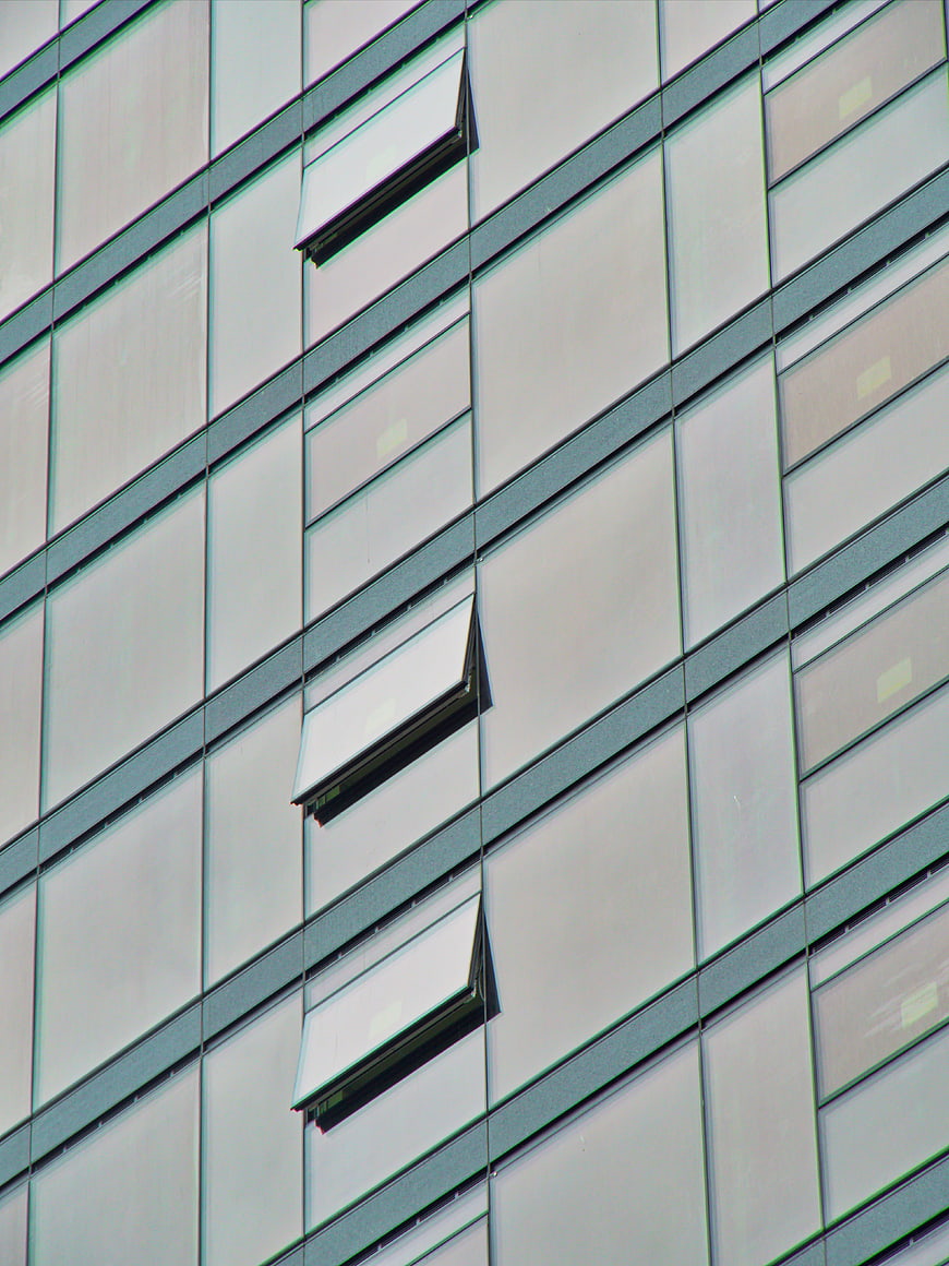 Modern glass office building facade with open windows