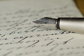 Close-up of vintage fountain pen nib on handwritten cursive letter