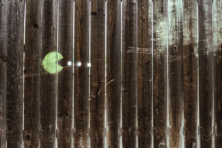 Pac-Man Graffiti on Weathered Wooden Fence