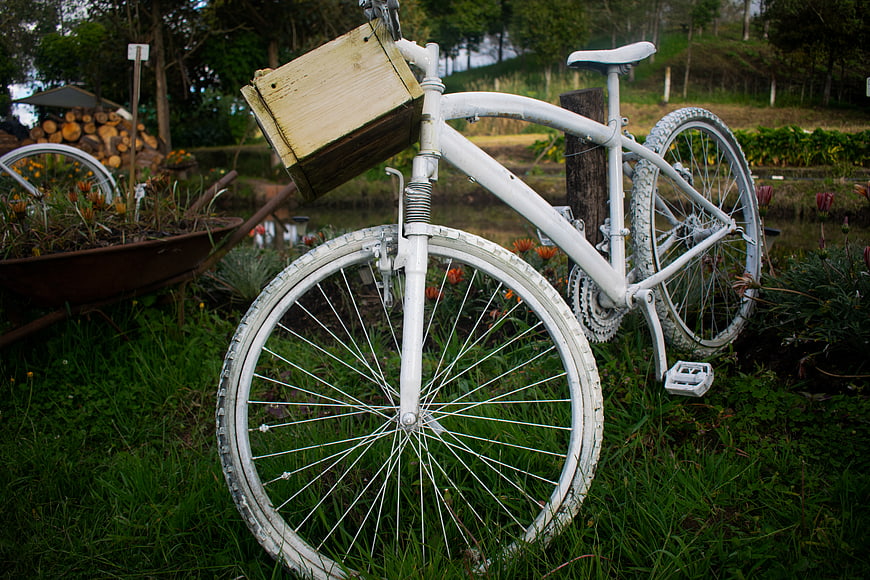 White Vintage Bicycle with Wooden Box in Garden