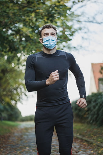 Man Running Outdoors Wearing Face Mask in Park