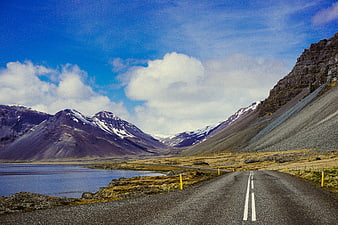 Scenic Mountain Road Winding Through Valley with Lake