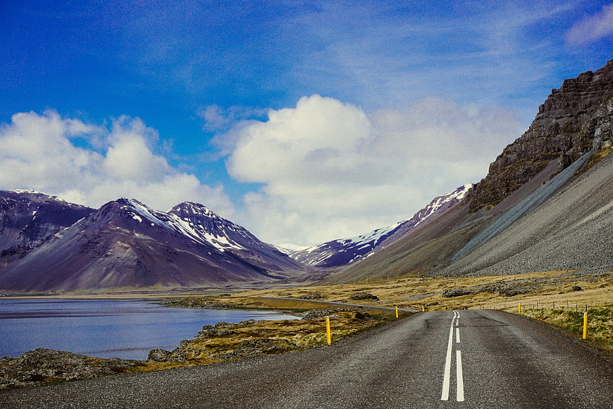 Scenic Mountain Road Winding Through Valley with Lake
