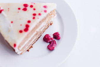 Slice of Raspberry Cheesecake with Fresh Berries on White Plate