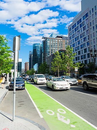 Urban street with green bike lane and modern city buildings