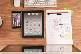 Flat lay of Apple devices and UX wireframe on wooden desk