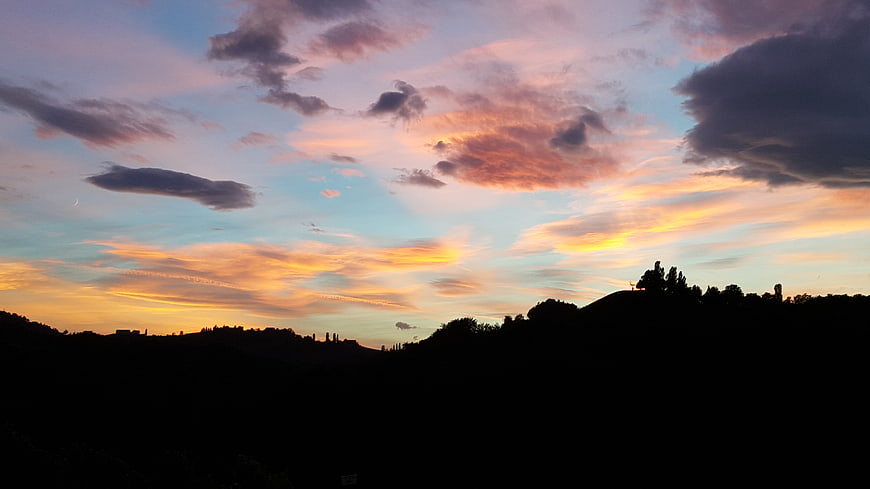 Dramatic sunset sky with colorful clouds over silhouetted hills