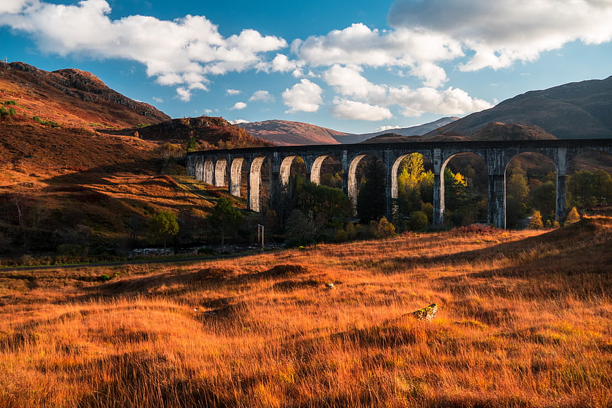 Glenfinnan Viaduct in Scotland with Autumn Hills and Blue Sky