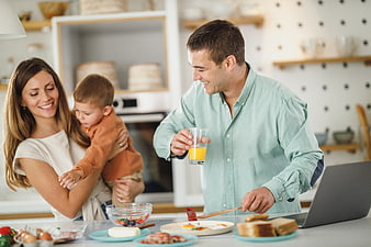 Happy family preparing breakfast together in modern kitchen