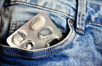 Blister pack of white pills in a blue denim jeans pocket