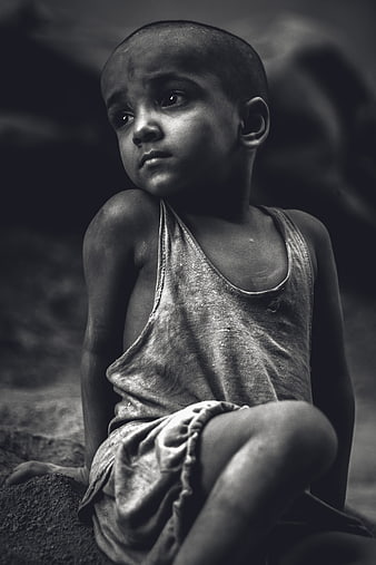 Black and white portrait of a young boy sitting outdoors