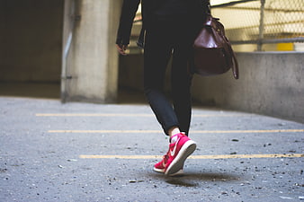 Woman Walking in Red Sneakers and Black Jeans