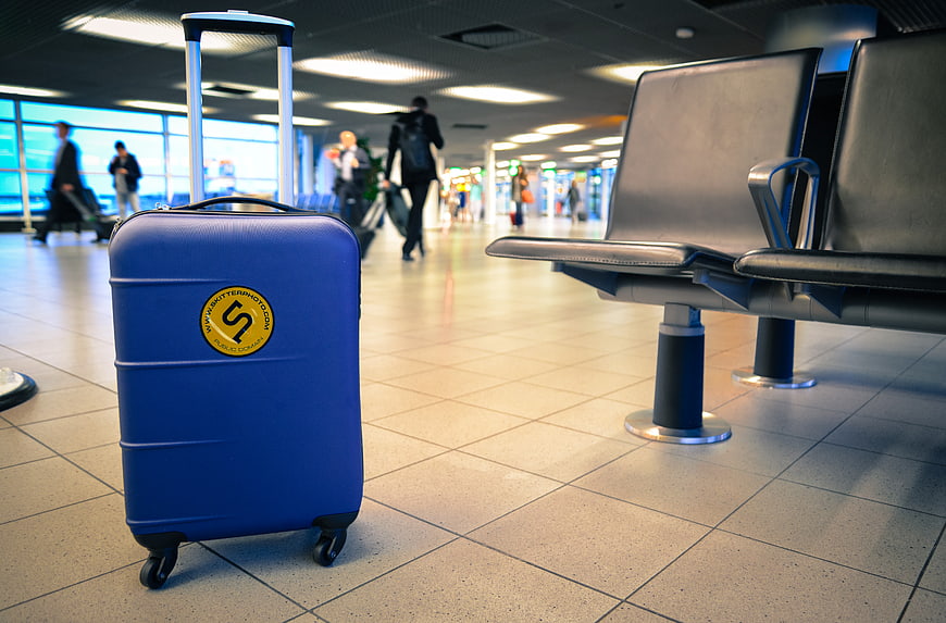 Blue suitcase in airport terminal waiting area